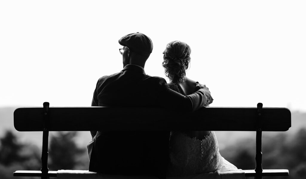 a black and white image of a couple sitting on the bench depicting one of the historical sex scandals