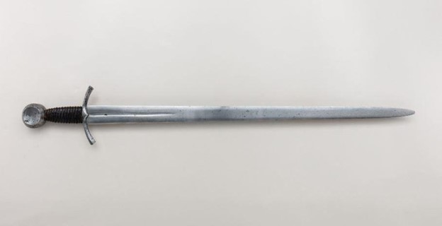 laid on a plain white surface is an arming or knightly sword, one of the sword types